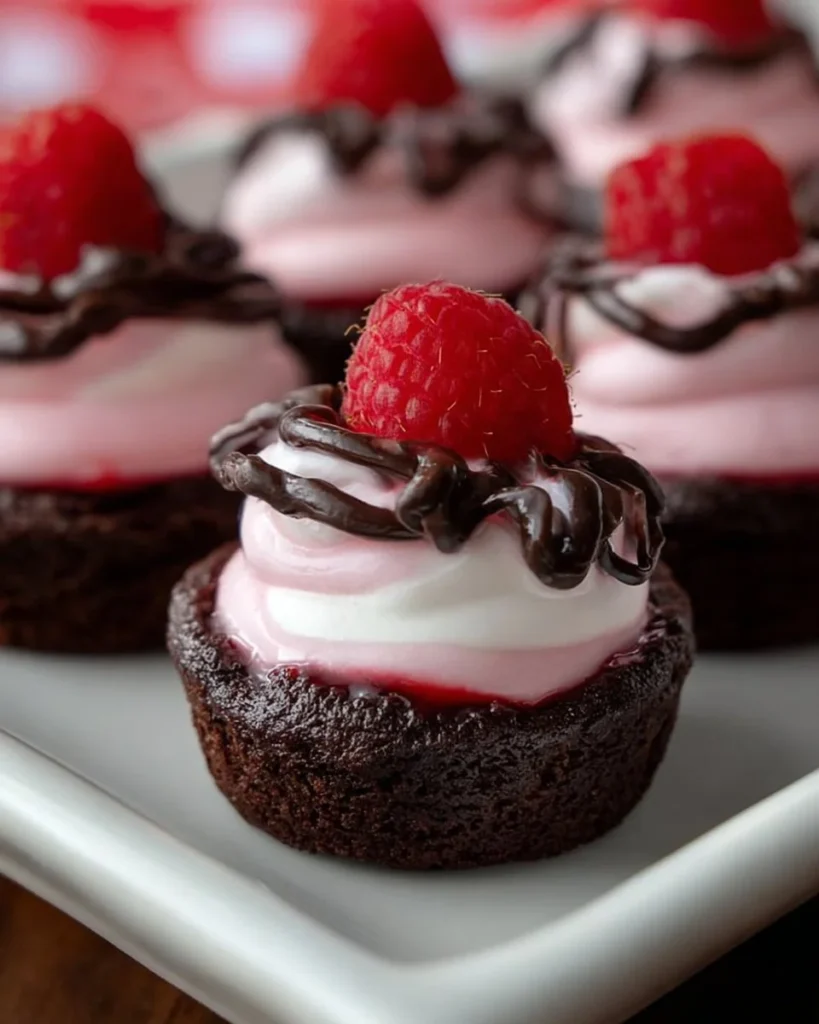 Raspberry Mousse Brownie Cups topped with fresh raspberries