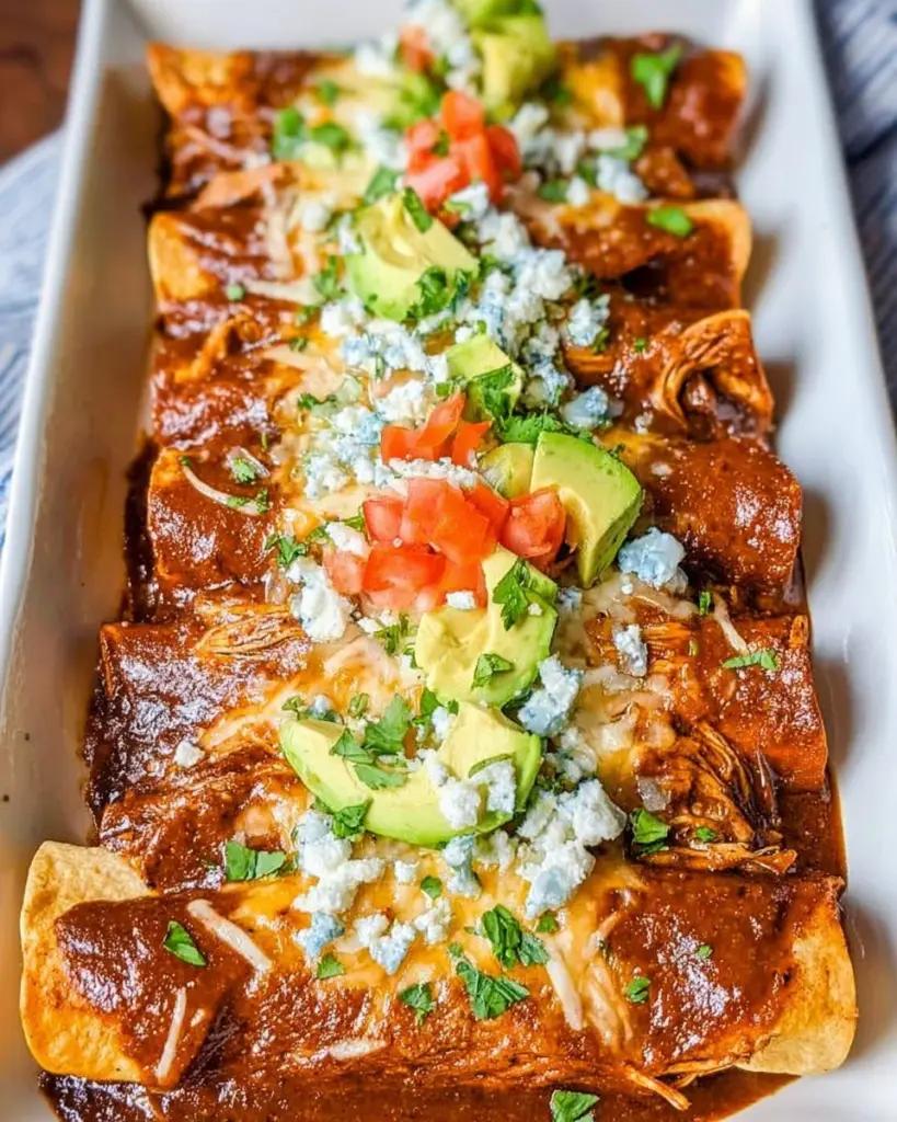 Delicious Mexican Mole Enchiladas topped with sauce and garnished with cilantro.