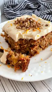 Delicious carrot cake sheet cake topped with cream cheese frosting and walnuts