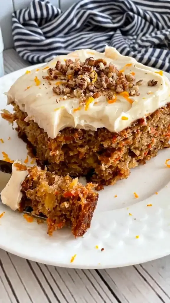 Delicious carrot cake sheet cake topped with cream cheese frosting and walnuts