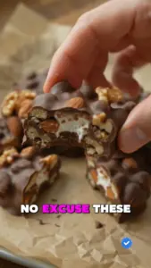 Delicious no-bake chocolate nut and marshmallow clusters on a white plate.