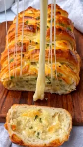 Freshly baked pull-apart garlic bread topped with herbs and melted butter.