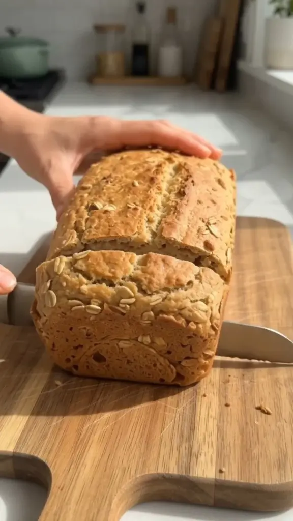 Slice of homemade 3-ingredient oat flour bread on a wooden board