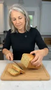 Sliced high-protein split pea bread on a wooden cutting board.