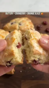 Freshly baked cranberry orange glazed cream scones on a plate