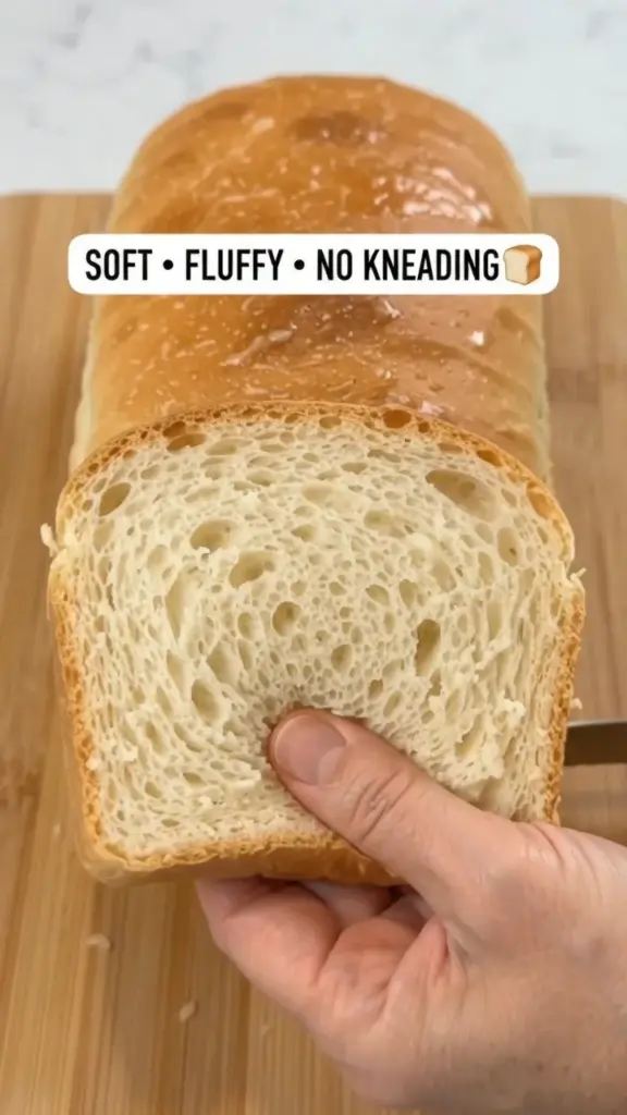Freshly baked no-knead homemade white bread loaf on a wooden table