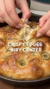 Mini cast iron focaccia baked with fresh herbs and olive oil