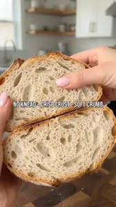 Freshly baked simple homemade no-knead bread on a wooden cutting board.