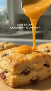 Soft and flaky cranberry orange scones on a wooden table