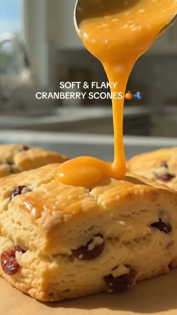 Soft and flaky cranberry orange scones on a wooden table